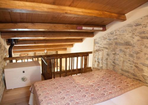 里奥马哲雷伊尔奈塔雷农家乐的一间卧室设有一张床和石墙
