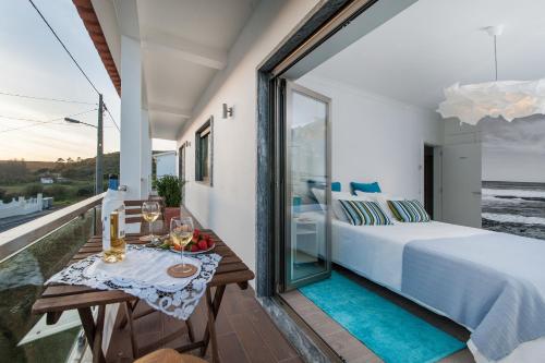 埃里塞拉Beachouse - Surf, Bed & Breakfast的一间卧室,阳台上配有一张床和一张桌子