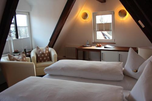 乌尔姆斯科尔斯豪斯酒店的一间卧室设有两张床、一张桌子和一个窗口。