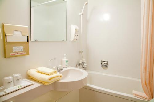仙北角馆民宿酒店的白色的浴室设有水槽和镜子