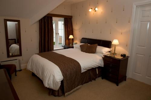 卡伦普顿Weir Mill Farm的一间卧室配有一张大床和镜子
