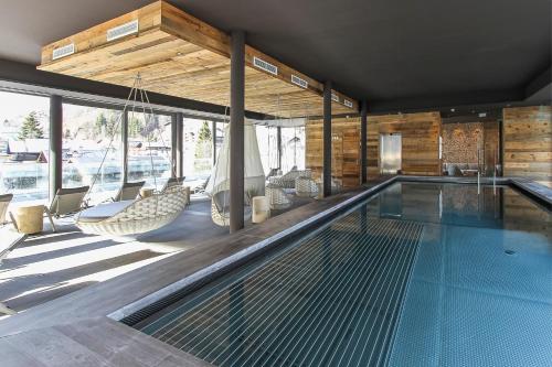 萨尔巴赫雪绒花酒店的房屋内带吊床和椅子的游泳池