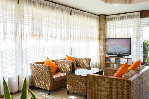 范县科宇维酒店的客厅配有藤椅和电视