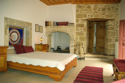 VóroiSior Nikoletos的一间卧室设有一张床和石墙