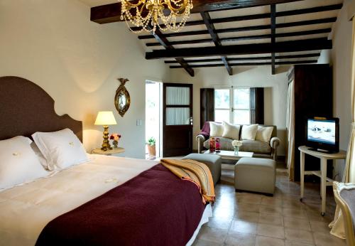 El EncónHouse of Jasmines Relais & Châteaux的一间卧室设有一张床和一间客厅。