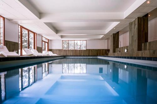 拉普德兹皮克布兰科酒店的一座带白色椅子的游泳池