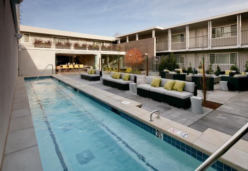 门洛帕克朗讯酒店的一个带长沙发的游泳池和一个酒店