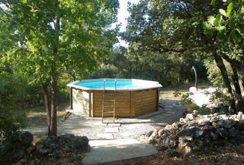 TavernesGite De Costebelle的树木繁茂的庭院中间的热水浴池
