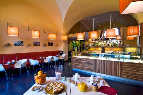加利亚诺德尔卡波Il Tabacchificio Hotel的一间餐厅,配有餐桌和食物
