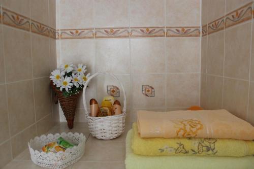 PontesturaCascina Fietta - Wine Dreams Apartments的浴室的角落,有篮子和鲜花