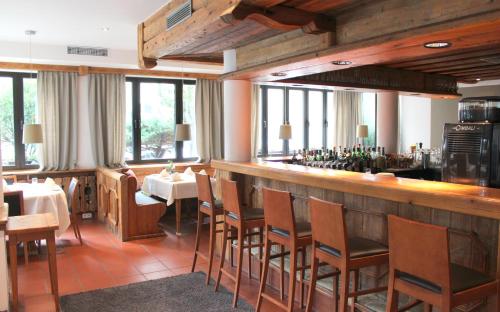 慕尼黑欧洲厄兹基瑟瑞酒店的餐厅设有酒吧,配有桌椅