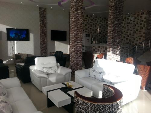 塞卡凯Lara Al Jawf Hotel Apartments的客厅配有2张白色沙发和电视