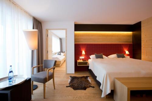 沃瑟姆阿尔伯格Hotel Walserstube的酒店客房设有一张大床和一张书桌。