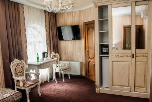 文尼察阿里斯托克拉酒店的配有桌椅和吊灯的客房
