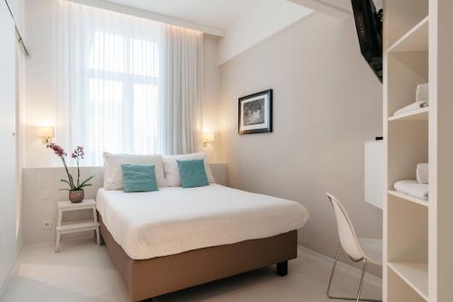 奥斯坦德奥斯坦德利奥波德酒店的一间小卧室,配有床和窗户