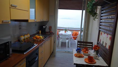 泰尔梅维利亚托雷海上阳台公寓的厨房配有水槽和桌子,享有海景