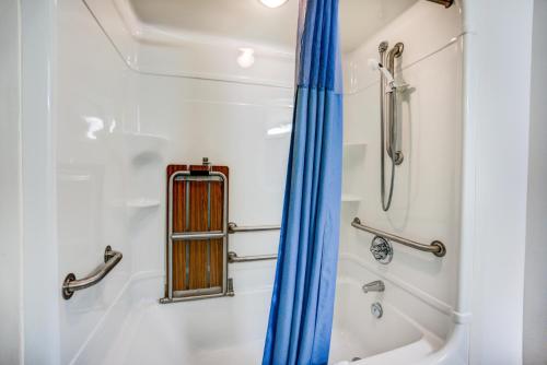 雷德迪尔雷德迪尔6号汽车旅馆的浴室内配有蓝色窗帘的淋浴