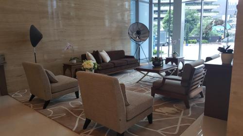 雅加达温莎招牌公寓的客厅配有沙发、椅子和桌子