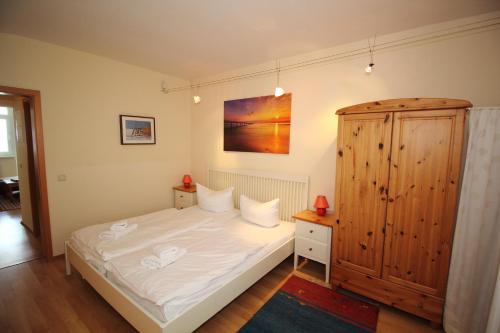 萨斯尼茨Fürstenhof - Apartment 405/406的一间卧室配有一张床和一个木制橱柜
