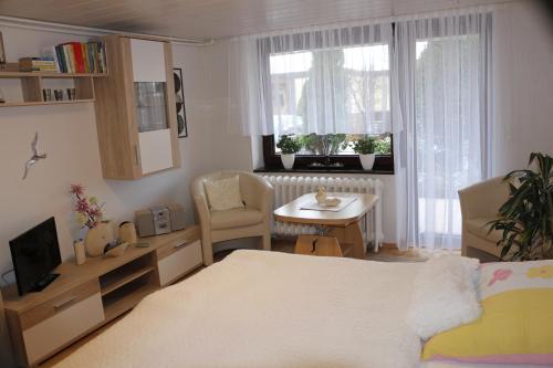 卑尔根吕根努尔劳波1号公寓的一间卧室配有一张床、一张桌子和一个窗户。