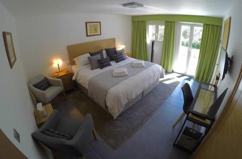 LantosqueLes Hortensias的一间卧室配有一张带绿色窗帘的大床