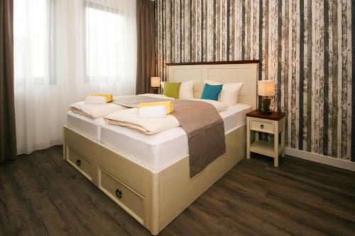 莱比锡莱比锡中央公寓式酒店的一间卧室配有一张大床和两个枕头