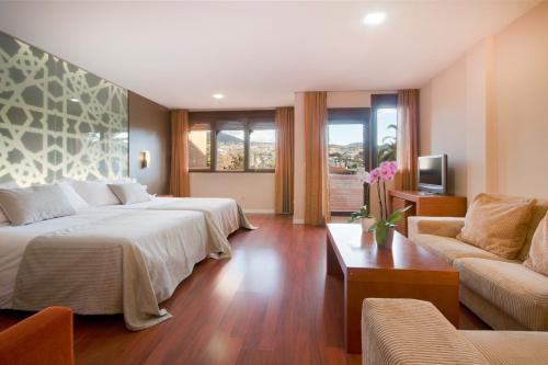 莫纳奇尔AH格拉纳达皇宫套房商务水疗酒店的酒店客房,设有两张床和一张沙发