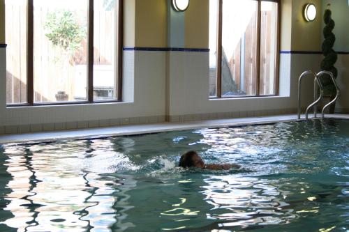 拉辛赫Lahinch Coast Hotel and Suites的女人在游泳池游泳