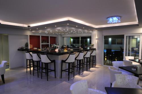伊利索斯Ialysos City Hotel的酒吧餐厅,带白凳