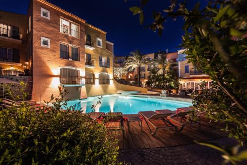 圣特罗佩圣特罗佩比布鲁斯酒店的游泳池,晚上有椅子和建筑