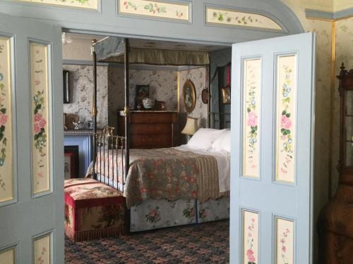 海斯廷斯圣本笃 - 维多利亚式住宿加早餐旅馆的一间卧室设有一张天蓬床和一个壁炉