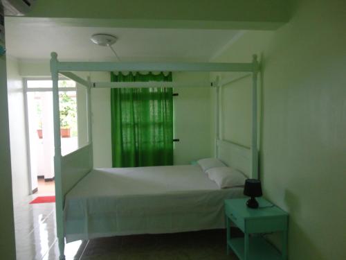 格兰贝伊阳光别墅的一间卧室配有一张天蓬床和窗户