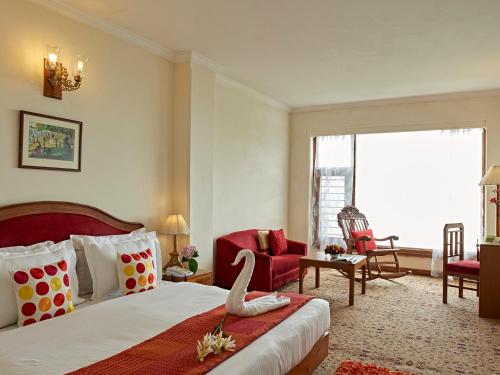 马舍布拉马辛德拉玛博瑞度假村的酒店客房,配有一张床和一张红色椅子
