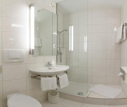 慕尼黑domus Hotel的白色的浴室设有水槽和淋浴。