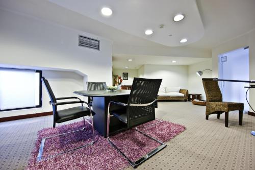 罗安达罗安达大陆酒店的客厅配有桌椅和沙发