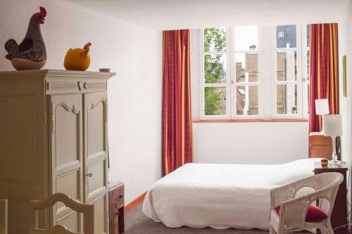 第戎Studio Lumineux, Coeur De Ville的一间卧室配有带梳妆台和窗户的床。