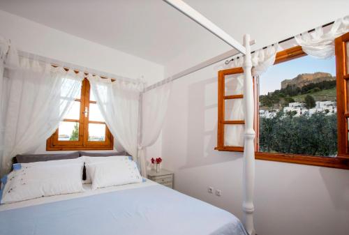 林都斯Lindos Seaside Villa的白色的卧室设有床和窗户