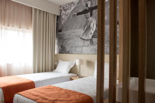 波尔图波尔图体育馆酒店的酒店客房设有两张床,墙上挂有绘画作品
