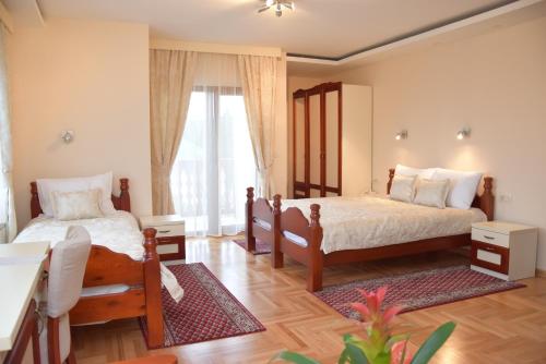 新瓦罗什IN Hotel Zlatar ex Zlatarski Biseri的一间卧室设有两张床和大窗户