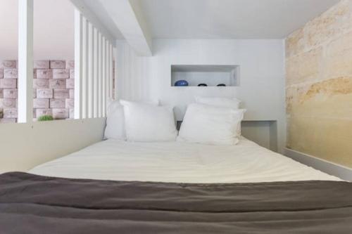波尔多圣米歇尔公寓的一间卧室配有带白色床单和枕头的床。