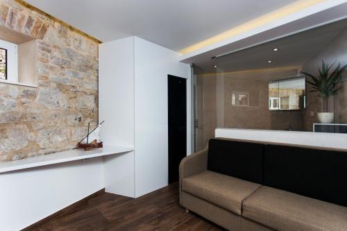 斯普利特Marinac City Center Apartments & Rooms的带沙发和石墙的客厅