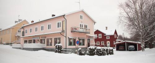 Dala-JärnaDala-Järna Hotell och Vandrarhem的前面的地面上积雪的建筑