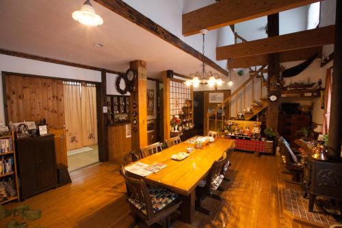 函馆乔库瑞膳食公寓的一间大型用餐室,配有木桌和椅子