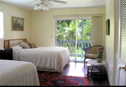 帕霍阿热带熔岩树美景酒店的一间卧室设有两张床和滑动玻璃门