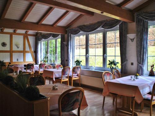 基希洪德姆Waldhotel Einstein的用餐室设有桌椅和窗户。