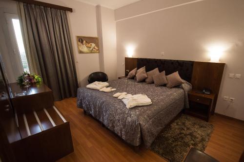 皮尔戈斯奥林波斯酒店的一间卧室配有一张床,上面有两条毛巾