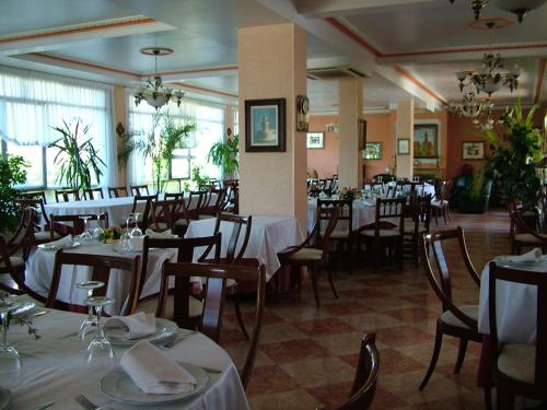Cuzcurrita-Río Tirón埃尔波特罗旅舍的餐厅配有桌椅和白色的桌布