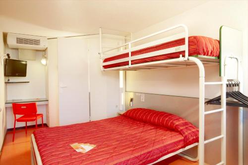 比亚里茨比亚里茨普瑞米尔经典酒店的一间卧室配有一张带红色床罩的双层床