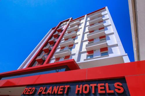 达沃市Red Planet Davao的一座高大的白色建筑,带有红色的行星酒店