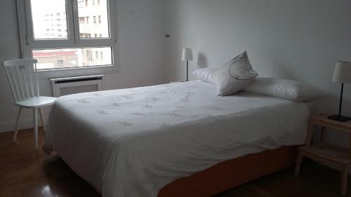 潘普洛纳Apartamento Vuelta del Castillo的窗户客房内的一张白色床